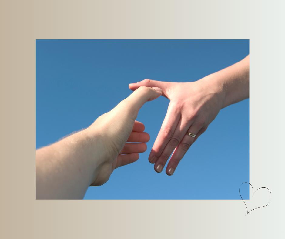 Zwei Hände reichen sich einander vor blauem Himmel.
