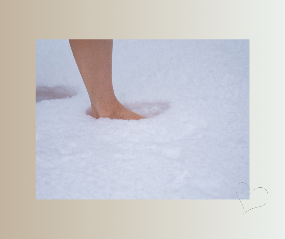 Ein nackter Fuß sinkt behutsam in frischen Schnee.