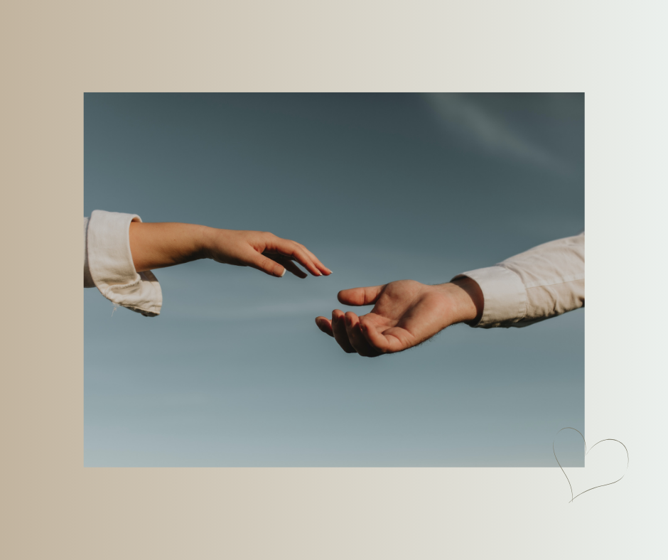 Zwei Hände erreichen sich einander vor einem ruhigen Himmel.