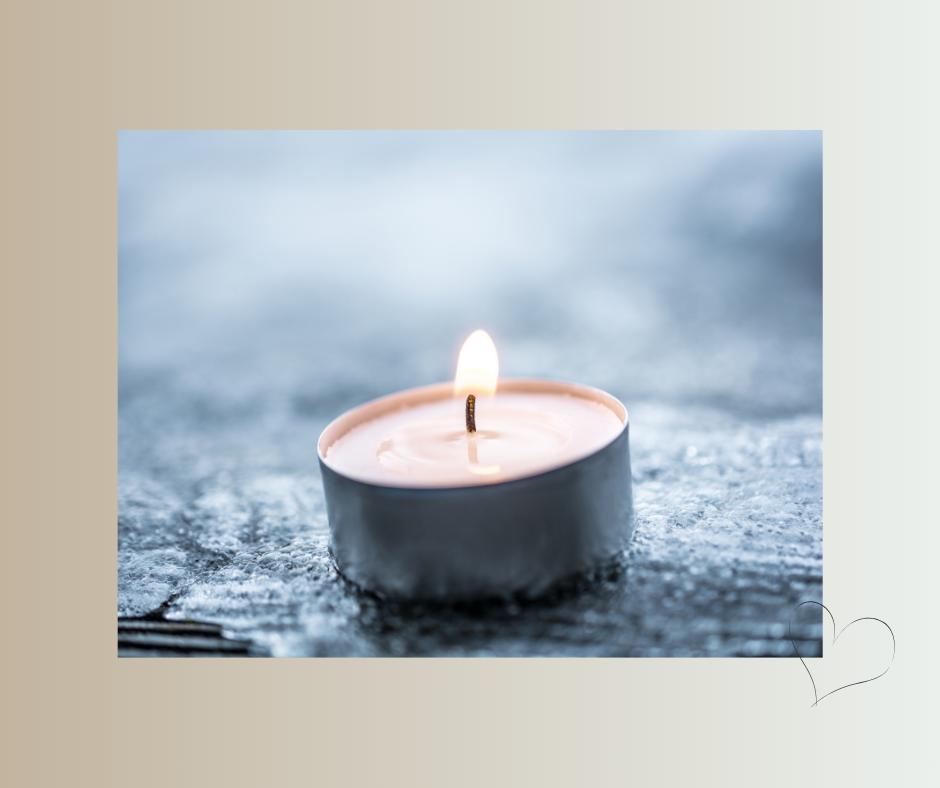 Brennendes Teelicht auf frostigem Untergrund – Ritual als Kraftquelle