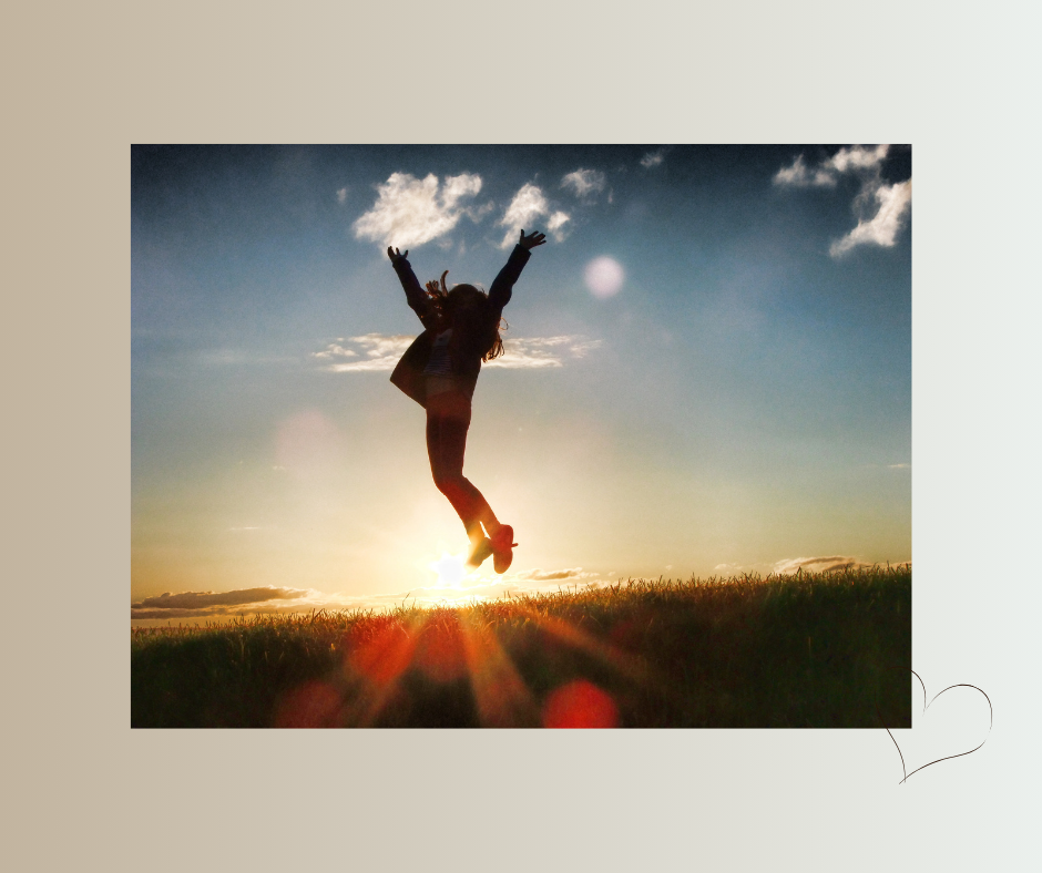 Frau springt mit ausgestreckten Armen ins Sonnenlicht – Symbol für Selbstbestimmung und neue Freiheit.
