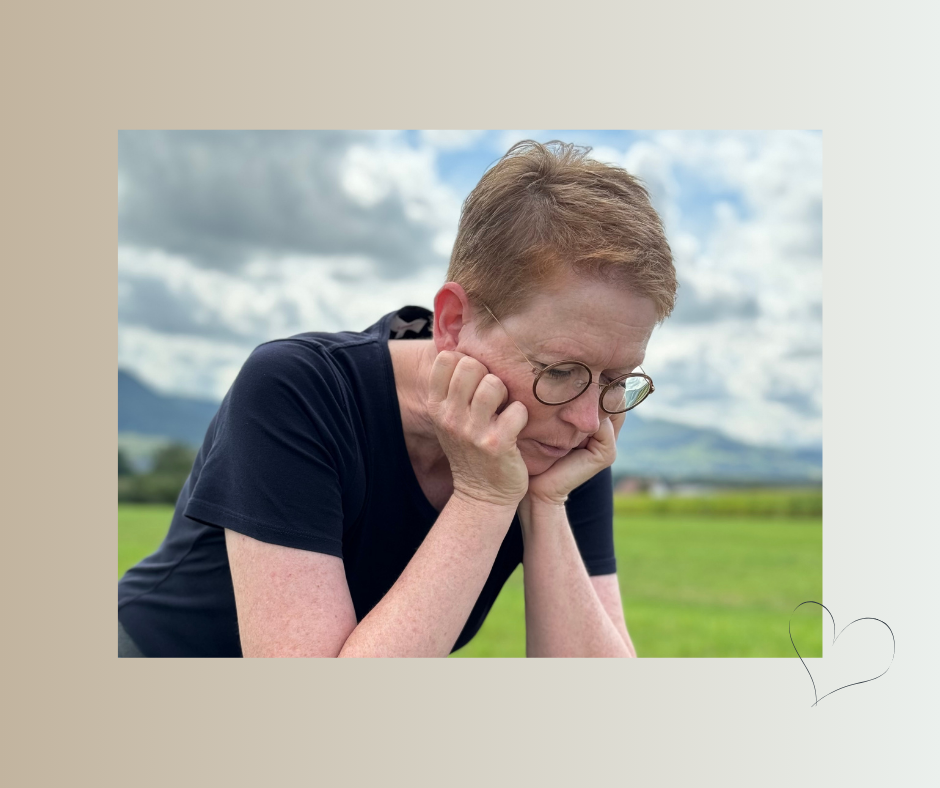 Frau in nachdenklicher Haltung auf einer Wiese – Moment der ehrlichen Innenschau